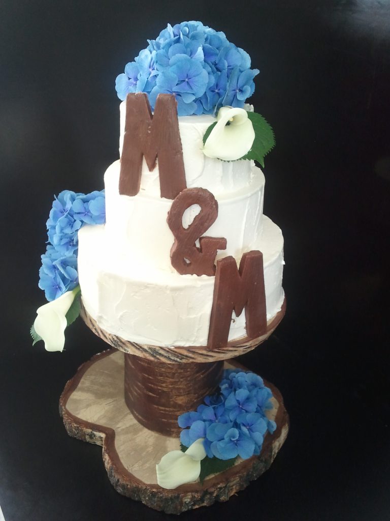 Rustikale Hochzeitstorte mit blauen Hortensien und Schoko-Buchstaben – Konditorei & Café Krüsmann Leipzig