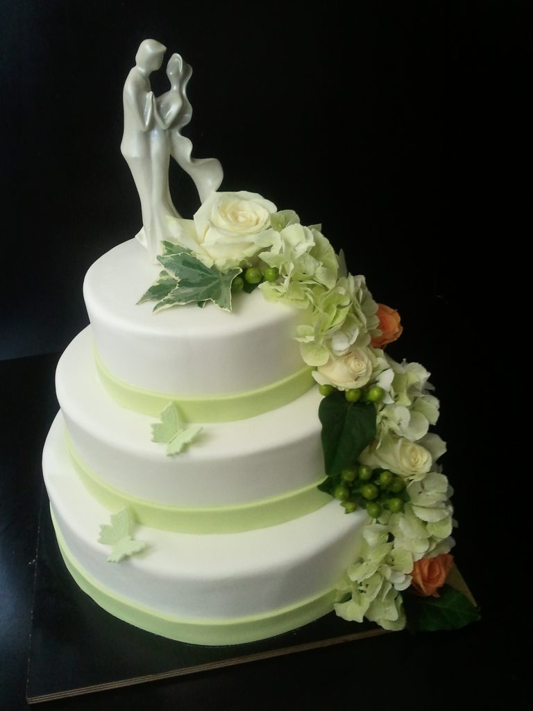 Dreistöckige Hochzeitstorte mit Brautpaarfigur und weißen Rosen von Konditorei & Café Krüsmann Leipzig