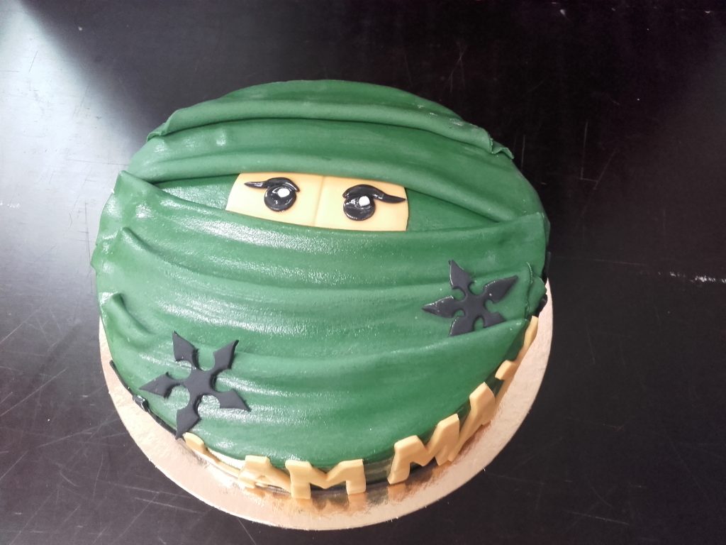 Ninja-Motivtorte mit grüner Maske, Wurfsternen und essbaren Details von Konditorei & Café Krüsmann Leipzig