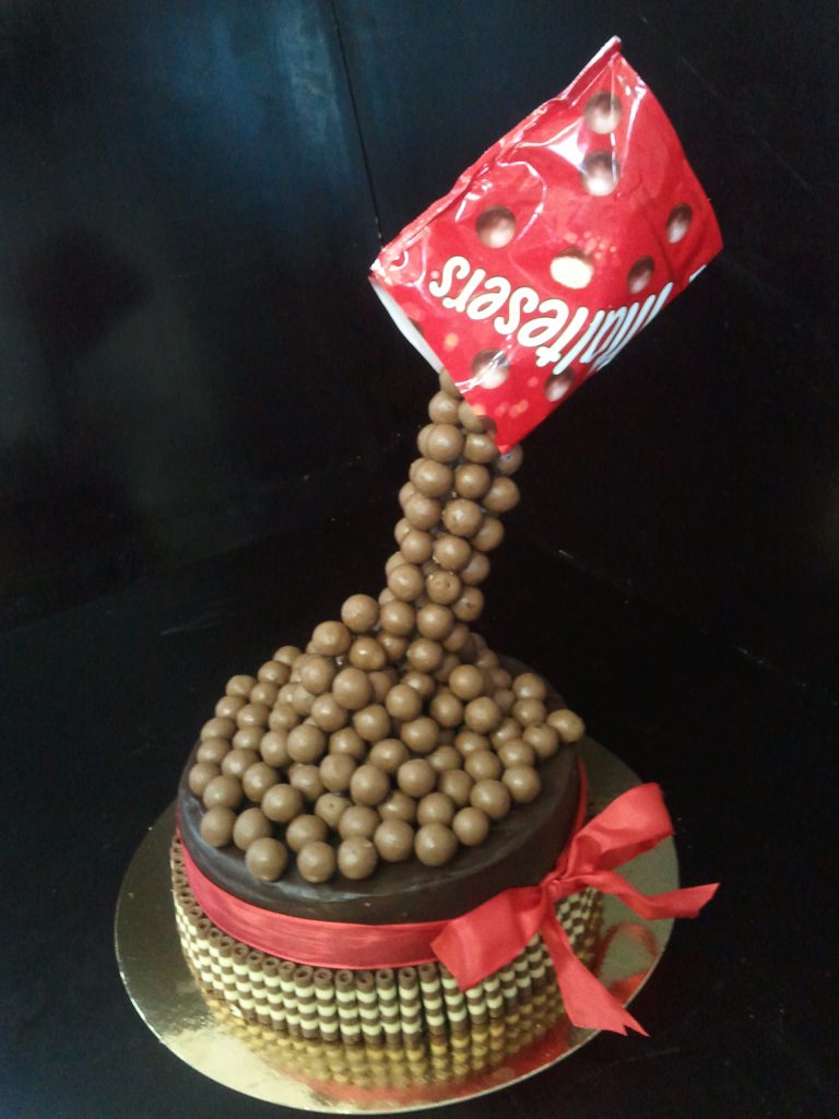 Schwebende Maltesers-Torte mit Schokoladenkugeln und roter Schleife von Konditorei & Café Krüsmann Leipzig
